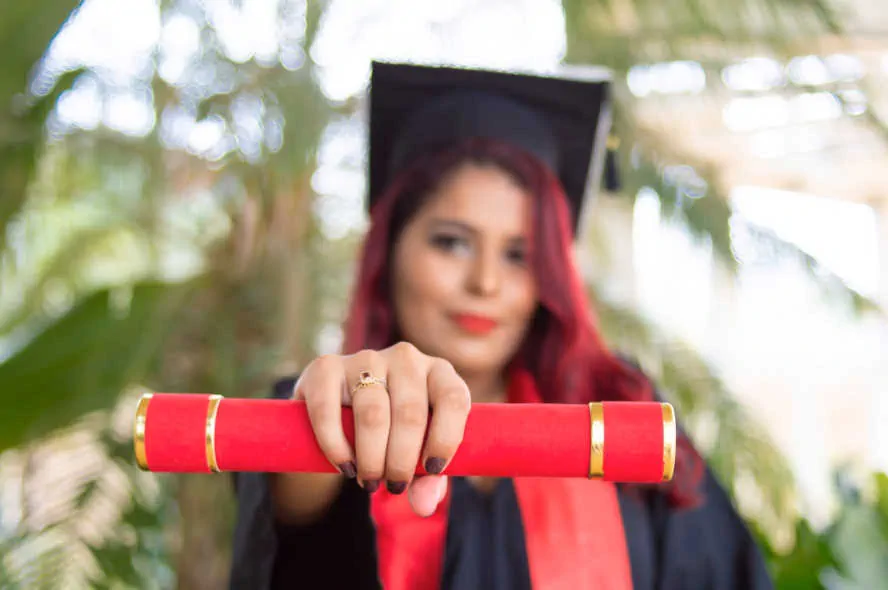 Woman holding college degree, a photo that will be shared on social media platforms.